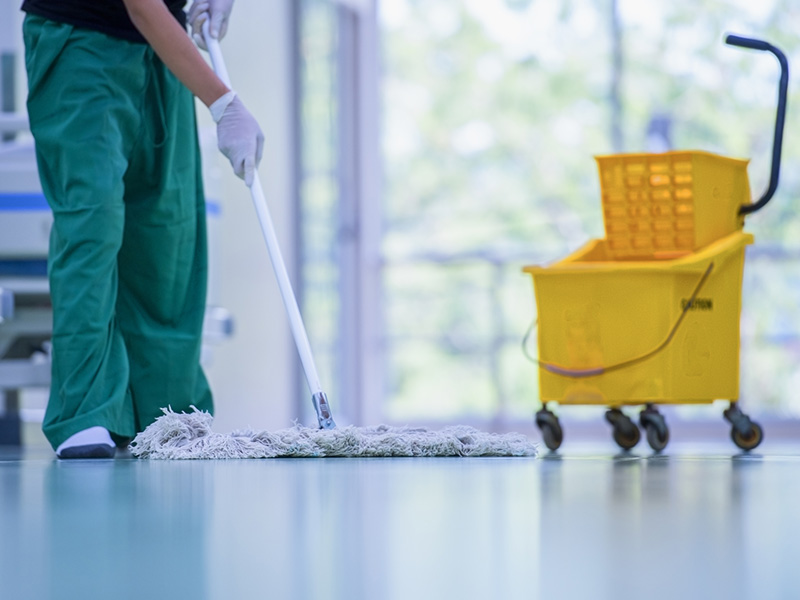 "Professional cleaner disinfecting a reception desk in a Greenwich, CT office building."